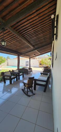 a covered patio with picnic tables and benches at Casa na Ilha da Crôa in Barra de Santo Antônio