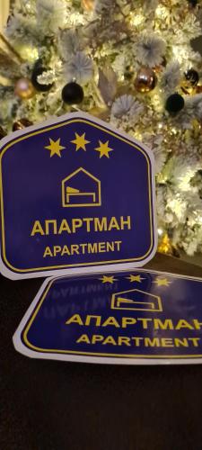 um sinal azul para uma nomeação apartmentariana ao lado de uma árvore de Natal em Grey & Sunny Apartments Zaječar em Zaječar
