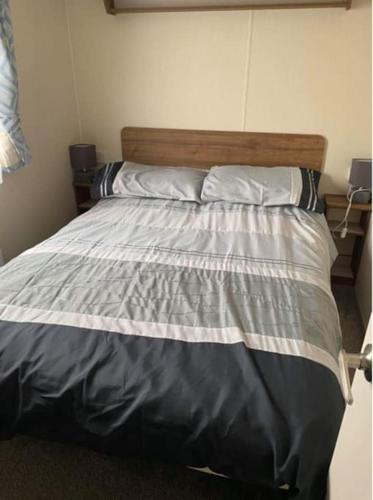 a bedroom with a large bed with a wooden headboard at A family-friendly, eight birth, 2019 Abbey Trieste Caravan in Morecambe
