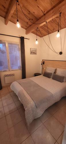 une chambre avec un grand lit dans une pièce avec des plafonds en bois dans l'établissement Maisonette de pays classée 3 étoiles, à La Cotinière