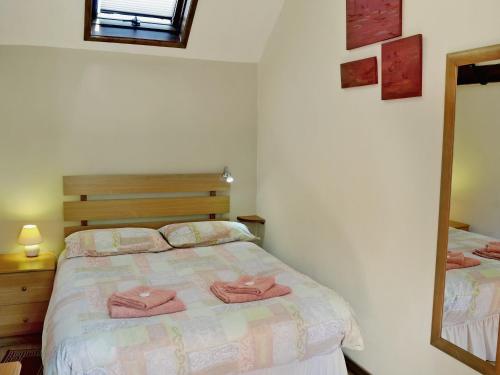 a bedroom with a bed with two pink towels on it at Thorpegate - E3076 in Thorpe Market