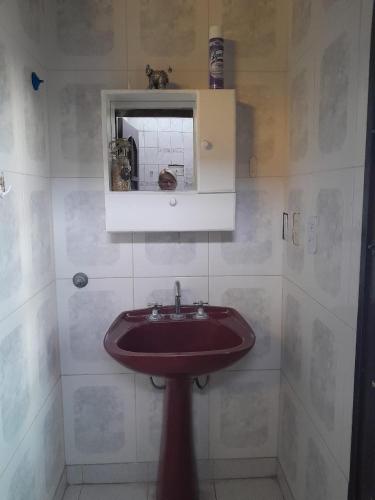 uma casa de banho com um lavatório vermelho e um espelho. em DEPARTAMENTO Alicia 2 em Santiago del Estero