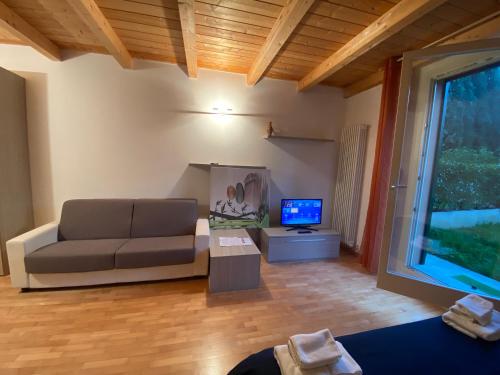 sala de estar con sofá y TV en Convent Palace, en Bolonia