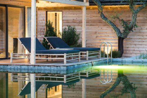 a swimming pool with two lounge chairs on a wooden deck at Sublime Comporta Country Retreat & SPA in Comporta