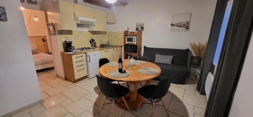 Una cocina con una mesa y sillas en una habitación. en Maisonette de pays classée 3 étoiles, en La Cotinière