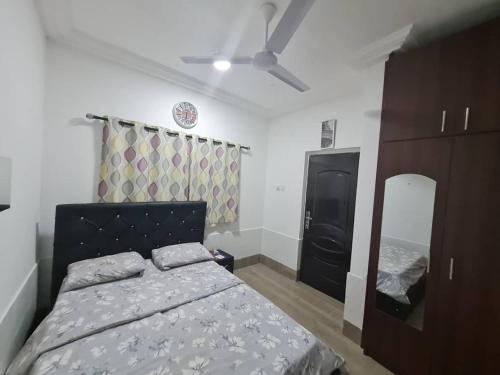 a bedroom with a bed and a dresser and a mirror at NESTA BARRON -Home Away from Home in North Legon