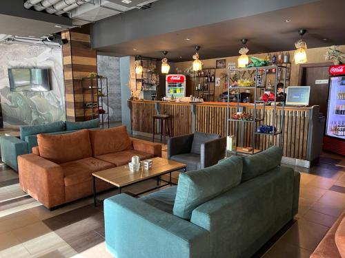 a restaurant with couches and tables and a bar at Borovets Gardens - Studio E 27 in Borovets