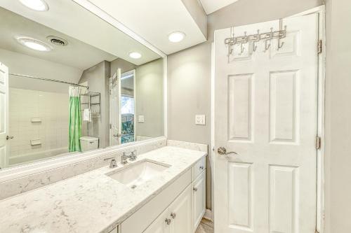 W białej łazience znajduje się umywalka i lustro. w obiekcie Queens Grant 750 w mieście Hilton Head Island