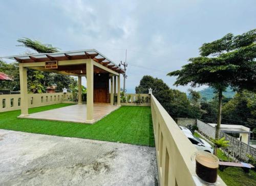 a backyard with a gazebo and green grass at Villa Names2 Gunung Bunder in Gunungpicung
