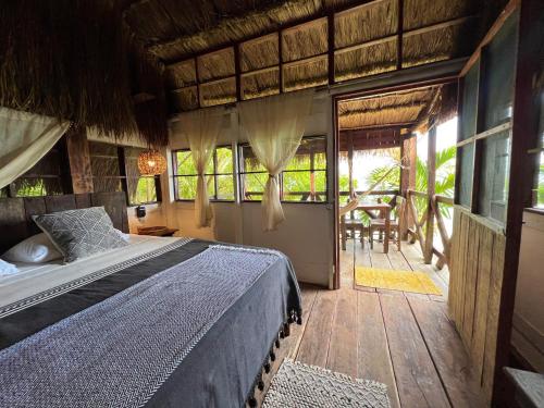 a bedroom with a bed and a wooden floor at Villa Santuario Lake front Oasis in Bacalar