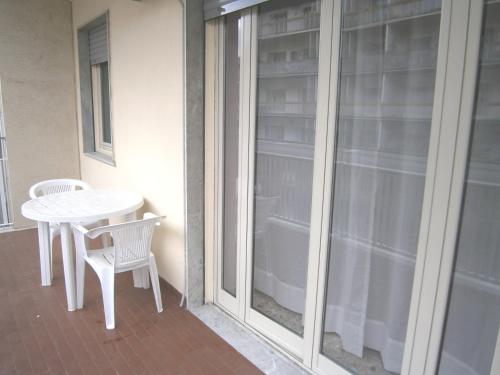 a white table and chairs next to a sliding glass door at Michelangelo Rooms in Catania