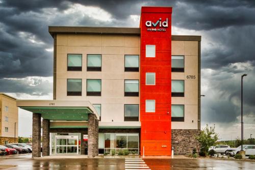 un edificio con una señal roja delante de él en Avid Hotels - Denver Airport Area, an IHG Hotel en Denver