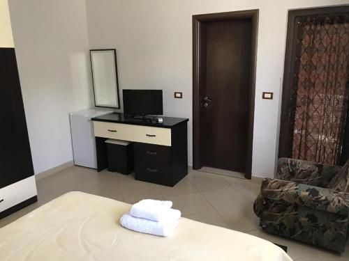 een kamer met een bureau met een spiegel en een stoel bij Hotel Camping Lin in Pogradec