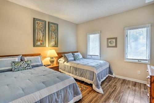 two beds in a room with two windows at Myrtle Beach Condo in Tidewater with Pool and Golf! in North Myrtle Beach