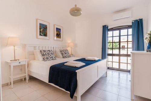 ein Schlafzimmer mit einem Bett mit einer blauen Decke in der Unterkunft StaySalty - Resort Style Family Beach House with Pool in Altura