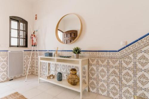 ein Badezimmer mit einer weißen Theke und einem Spiegel in der Unterkunft StaySalty - Resort Style Family Beach House with Pool in Altura