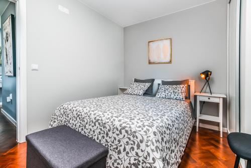 a bedroom with a bed with a black and white comforter at Rose House By Atlantic Holiday in Machico