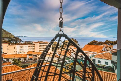 a view of a city from a swing at Rose House By Atlantic Holiday in Machico