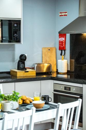 a kitchen with a table with a plate of food at Rose House By Atlantic Holiday in Machico