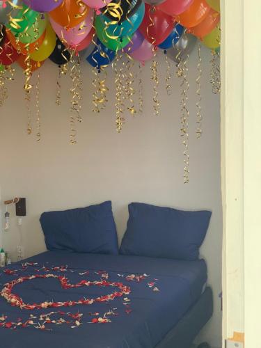 a bed with a bunch of balloons hanging on a wall at Boca Simon Vacation Curacao in Willemstad