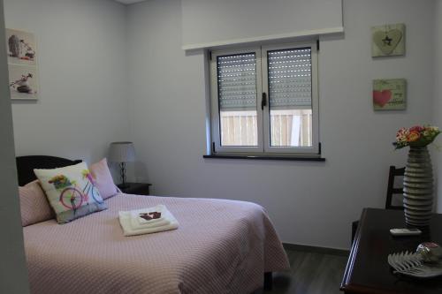 a bedroom with a bed and a window with a tray on it at Pedras Negras House in Biscoitos