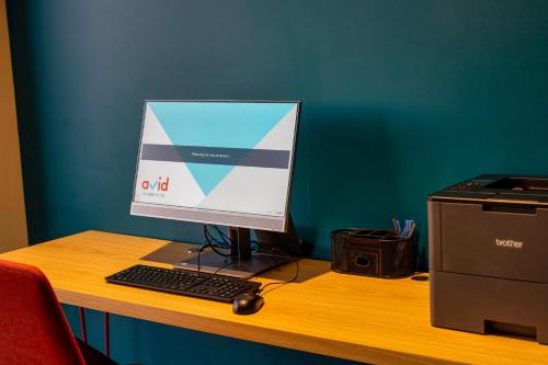 a computer monitor and a keyboard and mouse on a desk at Avid Hotels - Denver Airport Area by IHG in Denver