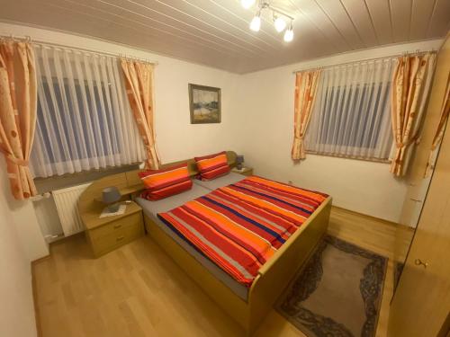 ein kleines Schlafzimmer mit einem Bett mit bunten Decken in der Unterkunft Ferienwohnung Frankenhof in Bad Steben