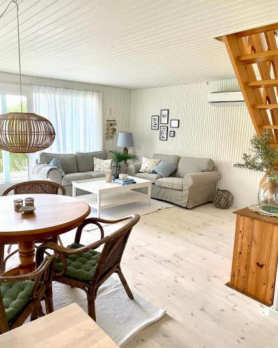 a living room with a couch and a table at Hyggeligt Sommerhus med havudsigt in Humble