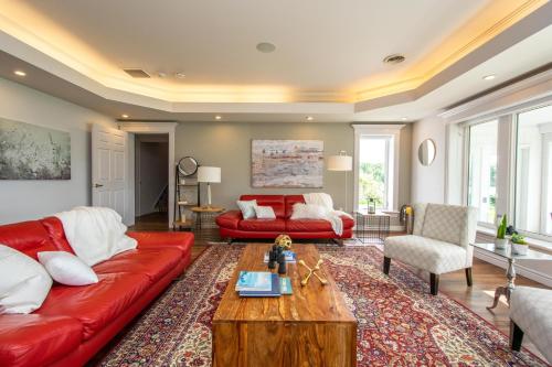 Sala de estar con sofá rojo y mesa de centro en OCEAN BAY VIEW Luxury Guesthouse, en Musquodoboit Harbour