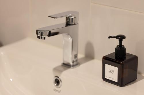 a bathroom sink with a faucet and a soap dispenser at AMIRI PLACE HOTEL in Chiang Mai