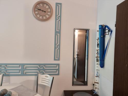 uma casa de banho com chuveiro e um relógio na parede em Апартамент BLUE SUMMER - уют, близо до морето em Burgas
