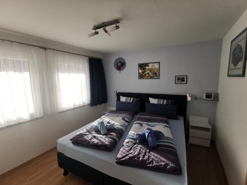 1 dormitorio con 1 cama con 2 almohadas en Ferienwohnung Aquileia, en Scuol
