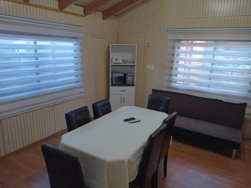une salle à manger avec une table et des chaises blanches dans l'établissement Cabañas Érica, à Choshuenco
