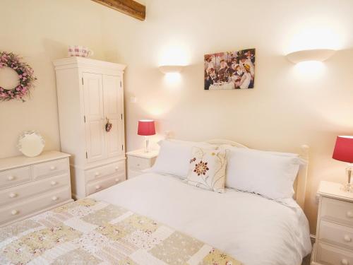 1 dormitorio con 1 cama con muebles blancos y 2 lámparas en Salem View - E5461 en Wainfleet All Saints