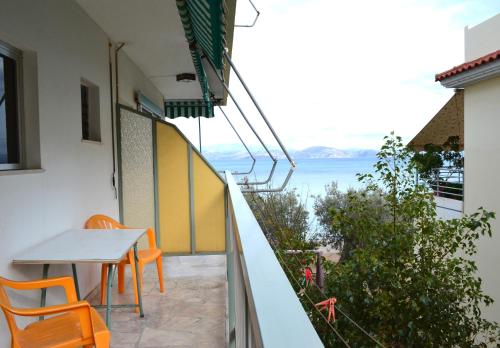 a balcony with a table and chairs and a view of the ocean at Oniro Apartments in Xiropigado