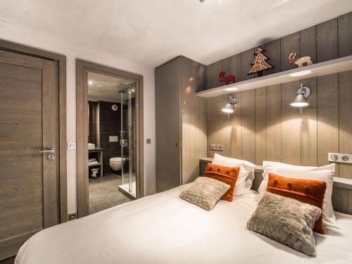 a bedroom with a large white bed and a bathroom at Appartement Courchevel 1650, 3 pièces, 6 personnes - FR-1-563-8 in Courchevel