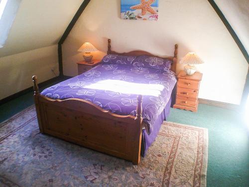 een slaapkamer met een bed met een paars dekbed bij Cider House in Hawkchurch