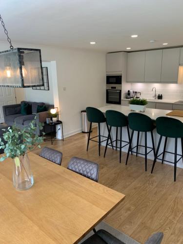 uma cozinha e sala de estar com mesa e cadeiras em Lux 2 Bedroom Ground Floor Apartment em Edimburgo