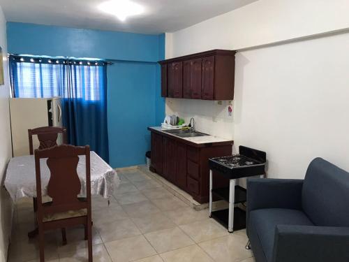 a living room with a couch and a kitchen at Hostal Magisterial Santo Domingo in Santo Domingo