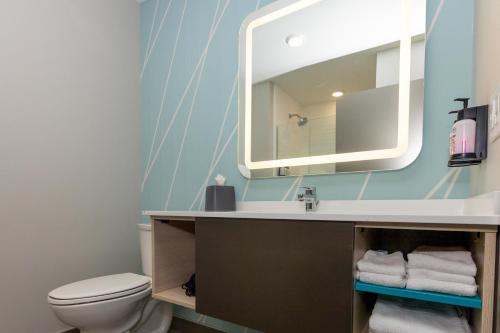 a bathroom with a sink and a mirror at Avid Hotels - Denver Airport Area by IHG in Denver