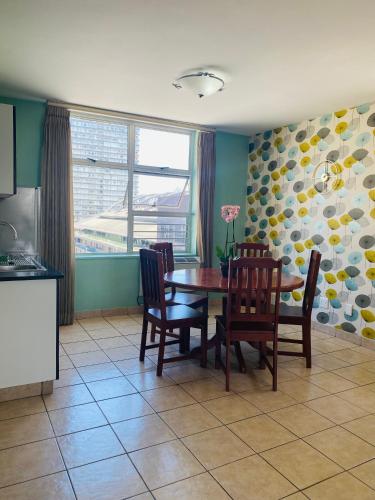 a kitchen and dining room with a table and chairs at Oceanic 2 Bedroom Apartment - City View - Self-Catering in Durban