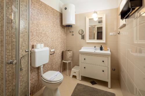 a bathroom with a toilet and a sink and a shower at Villa Perla in Krk