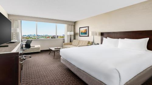 a large white bed in a hotel room with a window at Crowne Plaza Phoenix Airport - PHX by IHG in Phoenix