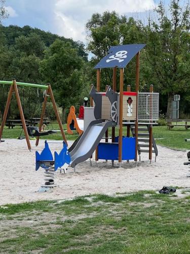 a playground with a slide in the sand at Cabane La Folie Douce in Hotton