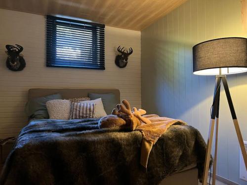 - une chambre avec un lit avec un animal rembourré dans l'établissement Cabane La Folie Douce, à Hotton