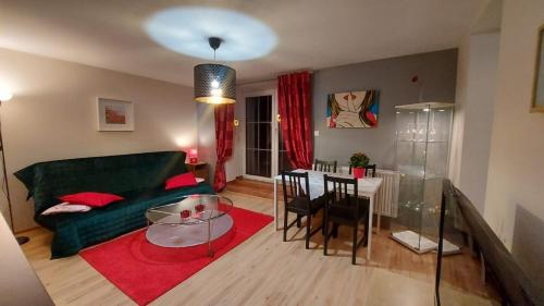 a living room with a green couch and a table at Apartamenty Stokrotka in Lądek-Zdrój