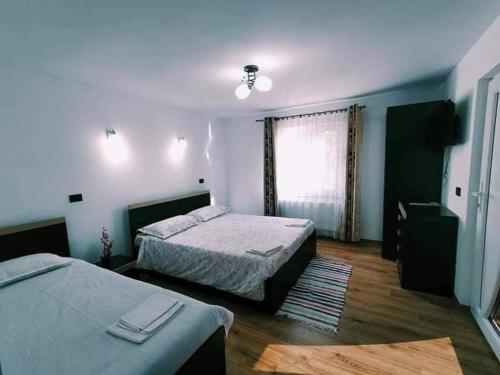 ein Hotelzimmer mit 2 Betten und einem Fenster in der Unterkunft Pensiunea Daniela in Moisei