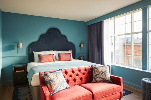 a bedroom with a bed and a red couch at Hotel Indigo - Exeter by IHG in Exeter