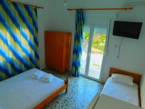 a small room with two beds and a television at Κωνσταντίνος Έλενα Studios in Pefki