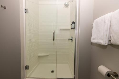 a shower with a glass door in a bathroom at Avid Hotels - Denver Airport Area by IHG in Denver